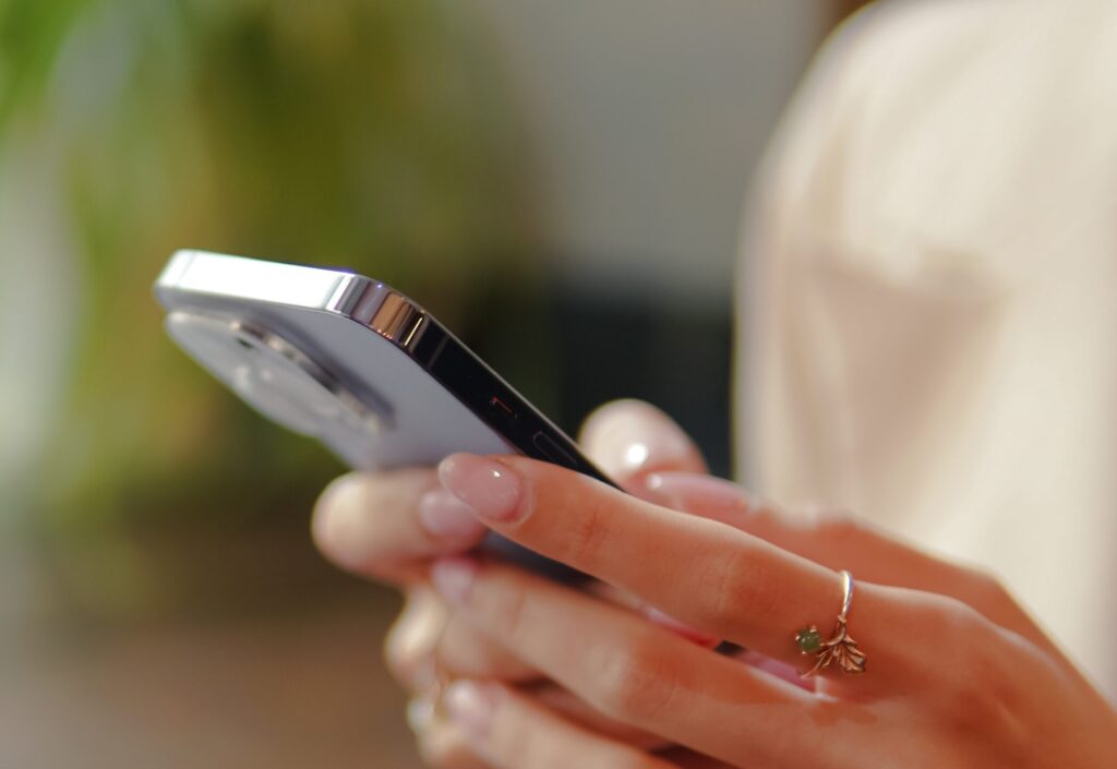 Young woman's hands texting on a mobile phone